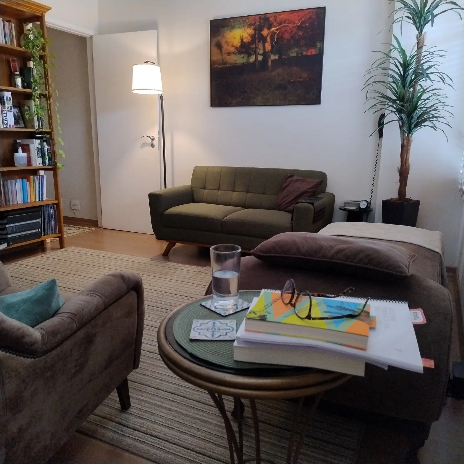 Consultório de Helder Barbosa, com poltronas, sofá, livros e iluminação acolhedora
